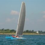 Catamaran de sport équipé d'une grand-voile en Mylar naviguant sur l'eau