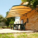 Pergola directement ancrée dans le mur d'une maison