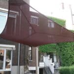 Meltem voile d'ombrage trapézoïdale sur la terrasses d'une maison classique